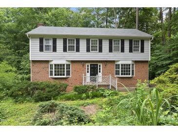 Charming two-story home with brick facade, complemented by black shutters and lush landscaping at 2004 Beecham Cir, Raleigh, NC 27607