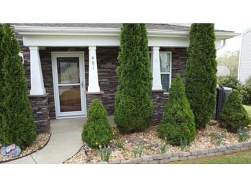 Charming front porch with stone accents and meticulously landscaped garden at 401 Lawton Dr, Haw River, NC 27258