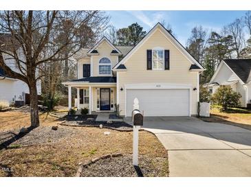 Charming two-story home with a manicured lawn and attached two-car garage at 405 Braxman Ln, Holly Springs, NC 27540
