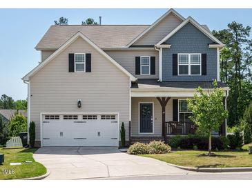 Charming two-story home with a two-car garage, covered porch, and attractive landscaping on a sunny day at 50 Dover Ridge Ct, Chapel Hill, NC 27517