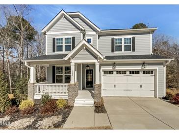 Charming two-story home with gray siding, black shutters, covered porch, and a two-car garage at 120 Breyla Way, Holly Springs, NC 27540