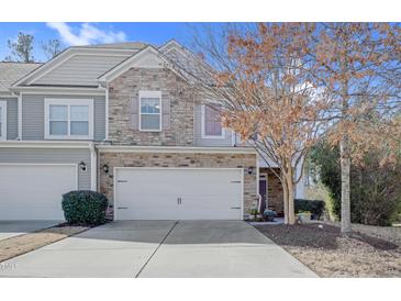 Charming townhome featuring a stone facade, two-car garage, and well-maintained landscaping at 146 Skyros Loop, Cary, NC 27519