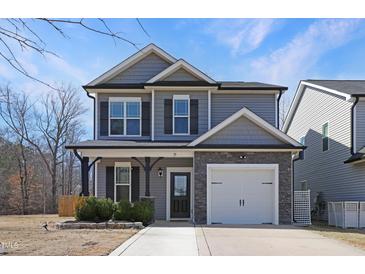 Charming two-story home featuring a manicured lawn, a two-car garage, and classic architectural details at 15 Mcdowell Pkwy, Clayton, NC 27520