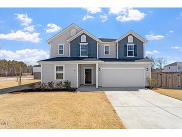 Two-story home with a two-car garage and a well-maintained lawn in a suburban neighborhood at 171 Piney Field Rd, Fuquay Varina, NC 27526