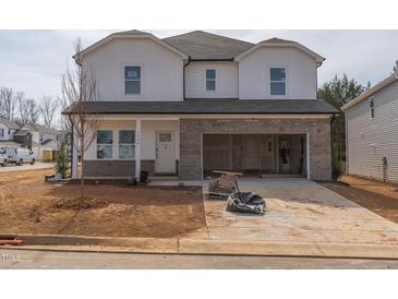 Two-story home featuring white siding, brick accents, and an attached two-car garage at 1720 Pie Filling Dr, Haw River, NC 27258