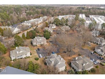 An aerial view of a community of gray homes surrounded by trees and parking lots at 2821 Edridge Ct # 102, Raleigh, NC 27612