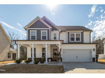 Beautiful two-story home with a covered front porch, white columns, and a two-car garage at 318 Highland Forest Dr, Fuquay Varina, NC 27526
