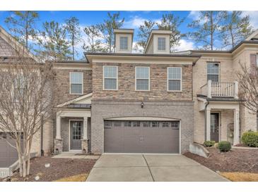 Charming townhome with stone and brick facade, two-car garage, and well-maintained landscaping at 410 Bent Tree Ln, Cary, NC 27519