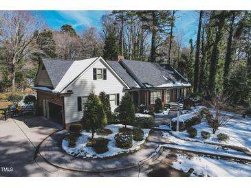 Charming single-Gathering home with a circular driveway and beautifully landscaped front yard covered with snow at 515 S Woodland Rd, Henderson, NC 27536