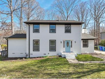 Charming two-story home featuring a classic white brick exterior and a light blue front door at 5704 Whippoorwill St, Durham, NC 27704