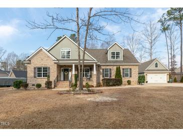 Charming brick home with a meticulously landscaped front yard, inviting curb appeal, and a detached two-car garage at 6236 Annabella Rd, Rocky Mount, NC 27803