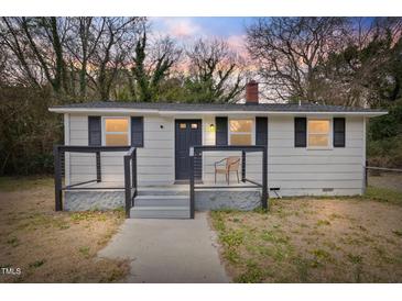 Charming front exterior featuring a quaint porch and neutral siding, exuding classic curb appeal at 700 Ross Rd, Lillington, NC 27546