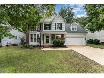 Charming two-story home featuring a well-manicured lawn, brick accents, and a two-car garage at 9249 Miranda Dr, Raleigh, NC 27617