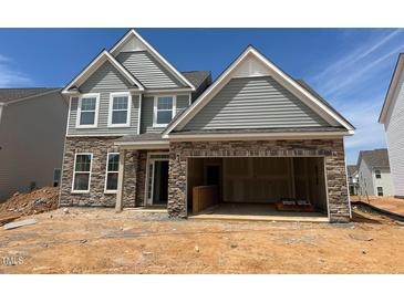Charming two-story home featuring stone accents, siding, and an attached two-car garage at 1016 Channel Drop Lp, Zebulon, NC 27597
