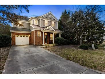 Charming two-story home featuring brick accents, a well-manicured lawn, and an attached two-car garage at 1104 Pebblestone Dr, Durham, NC 27703