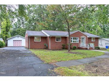 Charming brick home featuring mature trees, asphalt driveway and detached garage at 1418 Kirkwood Drive Dr, Durham, NC 27705