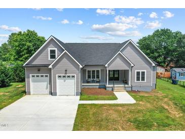 Charming single-Gathering home boasts a two-car garage, welcoming front porch, and a well-manicured lawn at 1604 Palmer Dr, Graham, NC 27253