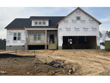 New two-story home under construction with a porch and attached garage at 18 Golden View Pl, Zebulon, NC 27597