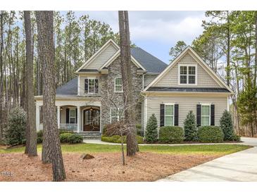 Beautiful home with stone accents, covered porch, and manicured landscaping at 242 Sweet Pine Cir, Pittsboro, NC 27312