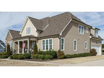 Beautiful two-story home with light brown siding, white trim, and manicured landscaping at 2609 Packhouse Rd, Zebulon, NC 27597