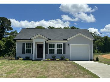 Charming single-Gathering home featuring gray siding, a black roof, a well-manicured lawn, and an attached garage at 272 Johnson Ridge Way, Four Oaks, NC 27524