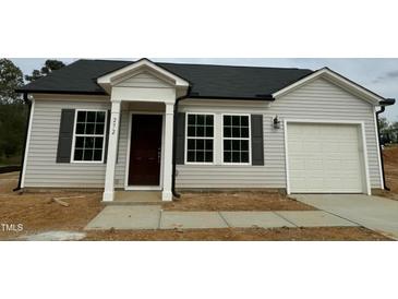 Charming single-story home featuring light siding, dark shutters, a garage, and a well-manicured lawn at 272 Johnson Ridge Way, Four Oaks, NC 27524