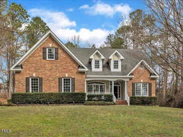 Charming brick home with manicured lawn, mature trees and a welcoming entrance at 5661 Quail Covey Ln, Wendell, NC 27591
