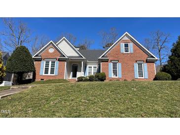 Charming brick home with a well-maintained lawn, blue shutters, and inviting curb appeal on a sunny day at 100 Sandy Hook Way, Cary, NC 27513