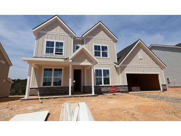 New two-story home with a two-car garage, covered front porch, and stone accents, situated on a lot under construction at 1204 Opal Ln # 93, Durham, NC 27705