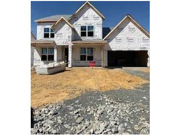 New construction featuring a two-story home design, showcasing a spacious garage and modern architectural elements at 1220 Opal Ln # 89, Durham, NC 27705