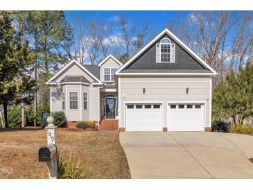 Charming two-story home with attached two-car garage, manicured lawn, and classic architectural details at 149 Winterberry St, Clayton, NC 27527