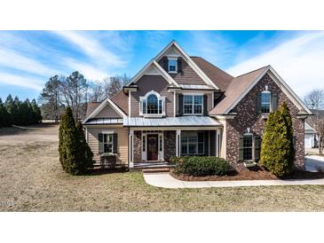 Two-story home with brick and shingle siding, complemented by mature landscaping and a covered front porch at 17 Beckwith Ave, Clayton, NC 27527