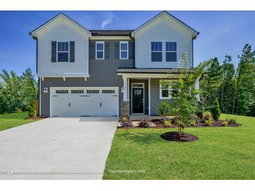 Charming two-story home featuring a welcoming entrance, a two car garage and landscaped front yard at 1803 Ballard Rd # Holly Craftsman, Fuquay Varina, NC 27526