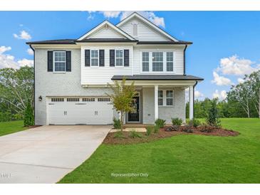 Charming two-story home features a light-brick facade, black shutters, and a well-manicured lawn at 1849 Ballard Rd # Holly Georgian, Fuquay Varina, NC 27526