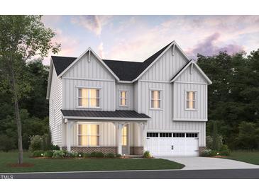 Inviting two-story home featuring white siding, black roof, brick foundation, and an attached two-car garage at 2004 Skipping Stone Dr # 165, Durham, NC 27705