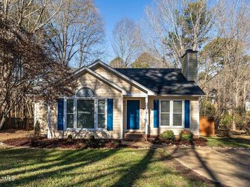 Charming one-story home featuring a manicured lawn, complemented by a vibrant blue front door and decorative shutters at 2116 Leadenhall Way, Raleigh, NC 27603