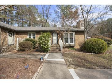 Charming brick home with a walkway leading to the front entrance, complemented by mature landscaping at 300 W Woodcroft Pkwy # 28D, Durham, NC 27713