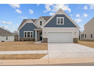 Charming two-story home with blue and white accents, a two-car garage, and a well-maintained lawn at 366 Tormore Dr, Sanford, NC 27330