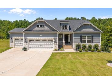 Charming home featuring a three-car garage and professionally landscaped front yard at 40 Cinnamon Teal Way, Youngsville, NC 27596