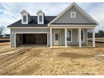 A charming single-Gathering home featuring light gray siding, a dark roof, and an attached two-car garage at 40 Eagle Crest Ct # Clayton Low Country, Lillington, NC 27546