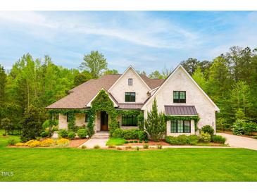 Charming two-story home featuring painted brick, lush landscaping, and a welcoming front porch at 5040 Shakori Trl, Chapel Hill, NC 27707