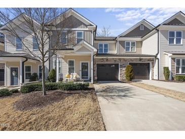 Charming townhome featuring a beige exterior, attached garage, and well-manicured landscaping at 510 Mariah Towns Way, Garner, NC 27529