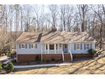 Charming one-story home with light blue siding, brick accents, and a welcoming front porch at 6021 Dickson Mill Rd, Durham, NC 27705