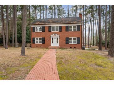 Charming two-story brick home with black shutters and a brick walkway through a tree-filled lot at 636 Palmer Dr, Sanford, NC 27330