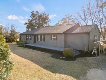 Charming single story home with gray siding, black trim, and landscaped front yard on a sunny day at 707 Memorial Ave, Dunn, NC 28334