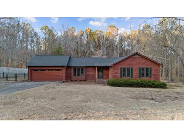 Charming single-Gathering home with a well-maintained lawn, an attached garage, and wood paneled siding at 1117 Pine Trl, Clayton, NC 27520