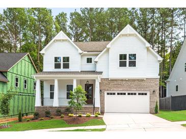 Charming two-story home with a brick and siding exterior, covered front porch, and attached two-car garage at 122 Sanderway Dr, Chapel Hill, NC 27516