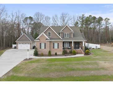 Charming brick home featuring a well-manicured lawn, a spacious driveway, and an attached two-car garage at 1320 Blue Heron Dr, Nashville, NC 27856
