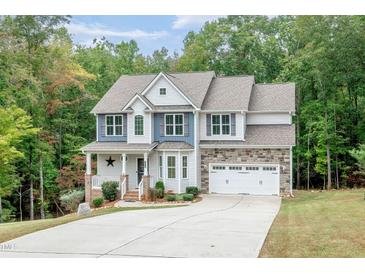 Charming two-story home with stone accents, a welcoming porch, and an attached two-car garage at 1354 Red Bud Ct, Wake Forest, NC 27587