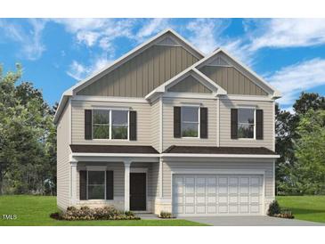 Charming two-story home featuring a two-car garage, neutral siding, and a well-manicured lawn at 27 Meath Ct # 215, Clayton, NC 27520